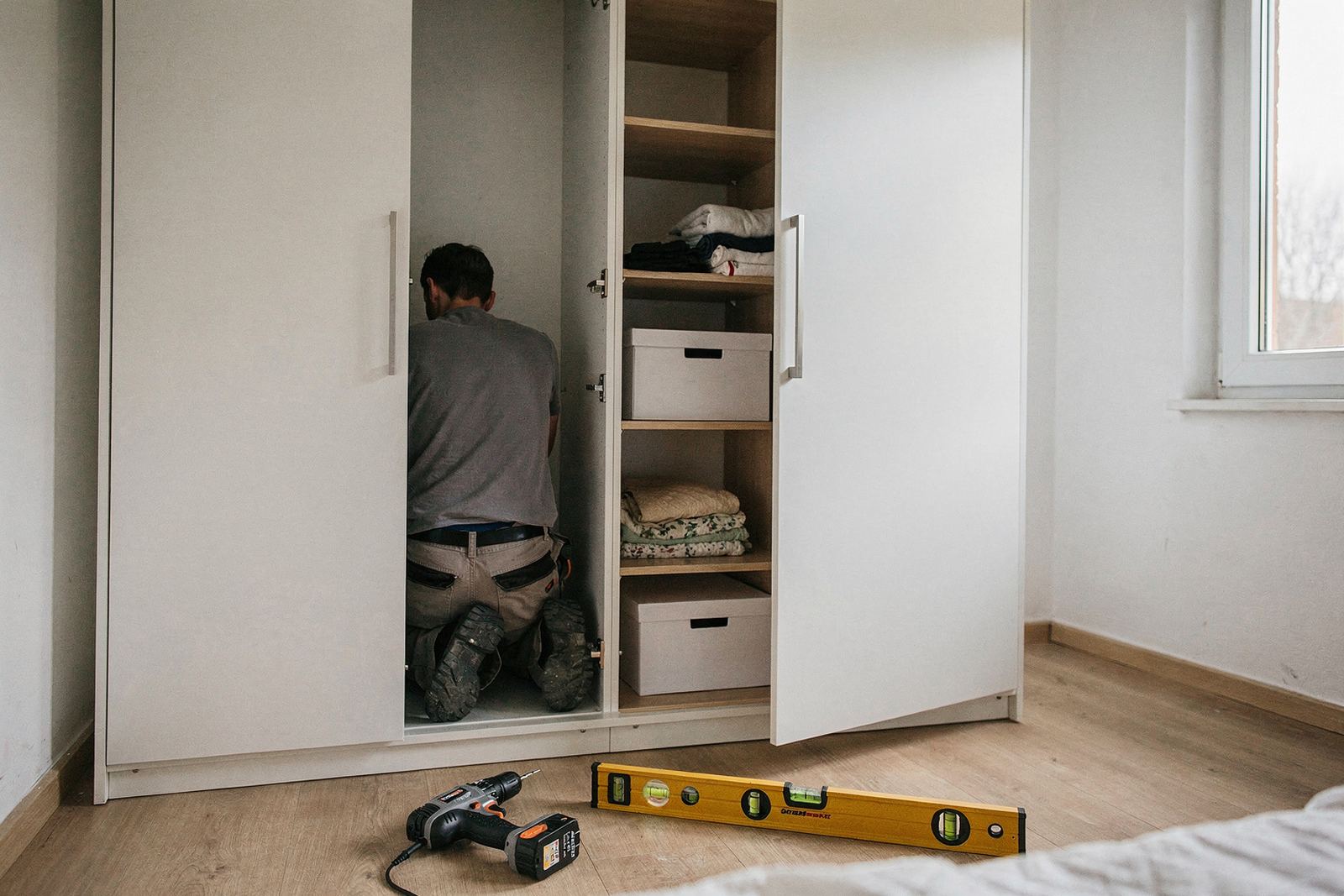 Symbolbild: Weißer Einbauschrank mit Schiebetüren in einer Wandnische